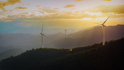 Scenic mountain view at sunset featuring wind turbines, highlighting the beauty of sustainable...