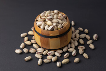 Pistachio in wood bowl on dark background