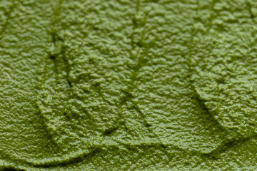 Close-up view of freshly made arugula pesto. Background texture.