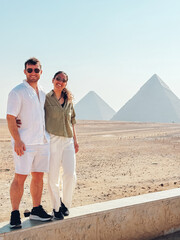 Tourists visiting giza pyramids in egypt on sunny day