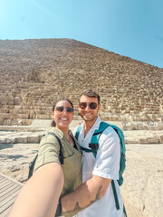 Tourists taking selfie in front of great pyramid of giza