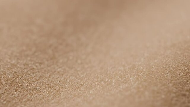 Closeup of light brown textured fabric with fine granular surface details subtly blurring into the background