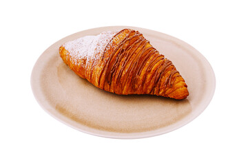 Delicious flaky croissant served on a round plate at a cafe