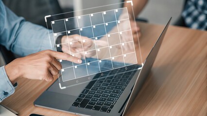 Managing Schedule Online: Person Interacting with a Digital Calendar Interface on a Laptop for Planning and Organization.