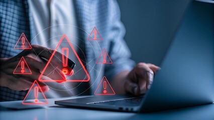 Person interacting with mobile device and laptop experiencing errors signaled by warning signs and digital overlay.