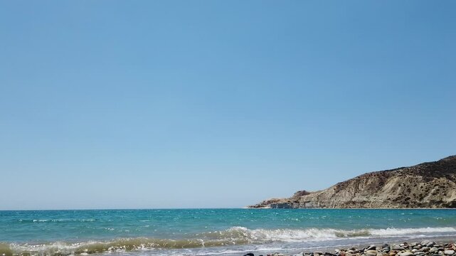 Gentle sea waves roll onto the shore at Pissouri Bay, Cyprus. Captured during a peaceful local walk by the beach, showing coastal charm, blue waters, and Mediterranean calm.