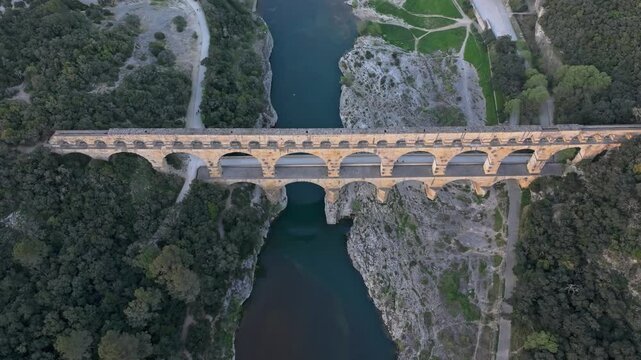 Aerial view of iconic Pont du Gard aqueduct illuminated by sunset hues