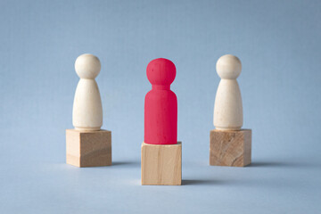 Red Wooden Figure Standing Out From the Crowd