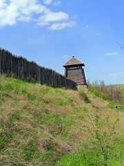 View from the foot of the hill on the ancient wooden fence surrounding the outbuildings of the Zaporizhian Sich.