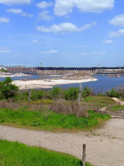View from the sandy path at the foot of the Zaporizhian Sich on the large rapids near the Dnieper Dam on a summer sunny day.