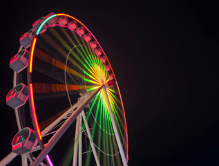 Fototapeta premium Ferris wheel shining brightly in the night sky at amusement park