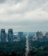 View of modern Kyiv skyline with towering buildings and a wide avenue under cloudy skies during the day showcasing urban life and architecture
