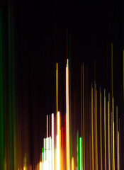 Vibrant streaks of neon light illuminate the night sky of a bustling city during a festive evening in early summer