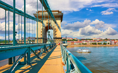 Chain bridge in Budapest, Hungary. Touristic travel boat on Danube river. Antique lanterns street...