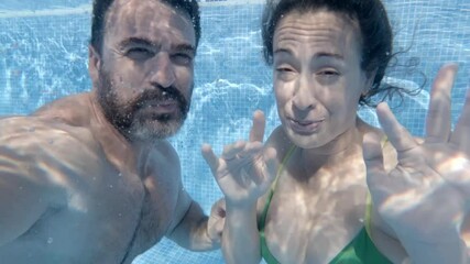 Romantic couple diving, kissing underwater, sharing intimate moment in bright blue pool, highlighting passionate connection - Powered by Adobe