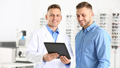 Ophthalmologist showing tablet to patient in optical store