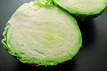 Fresh green cabbage with a half on a black background.
Fresh ripe cabbage. Vegetarianism. The...