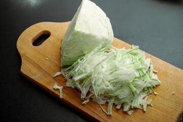 Fresh green cabbage cut into strips on a black background.
Fresh ripe cabbage. Shredded cabbage....