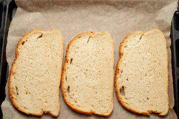Close-up of tomato bruschetta on artisan bread slices with fresh sliced ​​tomatoes, parmesan cheese and herbs on a baking sheet in the oven while cooking. Food preparation process, bruschetta, sandwic