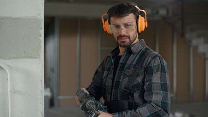 Repairman builder man Caucasian guy drilling wall with hammer drill repair renovation building...