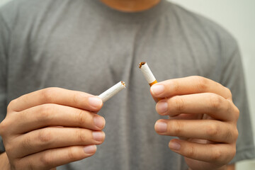 Quit smoking, Asian teenage man breaking destroy cigarette in hand.