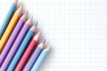 Colorful pencils on grid paper, a school-themed background with space for text or design