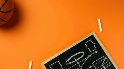 Basketball next to strategy board on orange background - Powered by Adobe