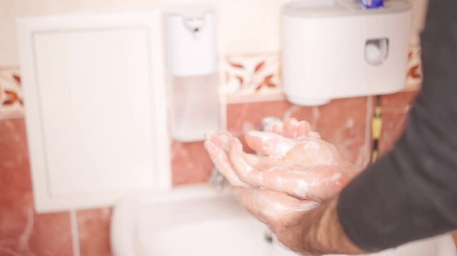 Hand washing demonstration showing proper technique in a clean bathroom setting
