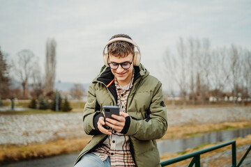 Young adult caucasian student smile and using smart phone to talk or take self portrait