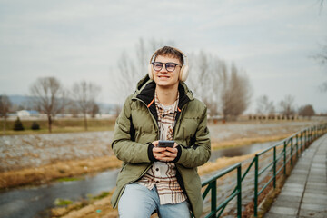 Young adult caucasian student smile and using smart phone to talk or take self portrait