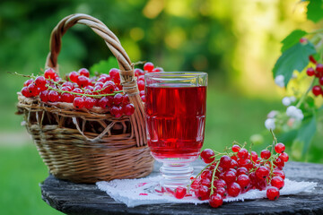 Ripe red currant berry and juice on old country house table background.