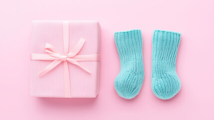 Pair of small baby socks and gift box on pink background, baby shower backdrop, first newborn baby.
