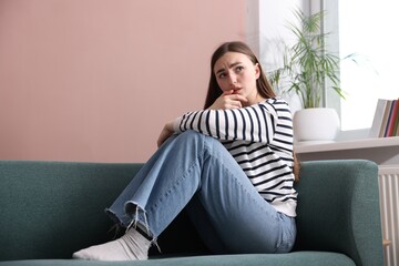 Woman suffering from paranoia on sofa at home