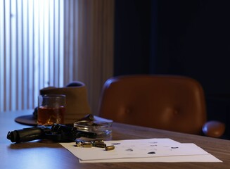 Gun, fingerprints, whiskey and other stuff on wooden table in mafia boss office