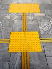 yellow tactile paving is installed to assist visually impaired individuals in safely navigating...