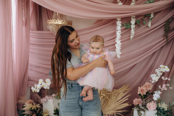 In cute dress. Happy mother is with her baby daughter indoors
