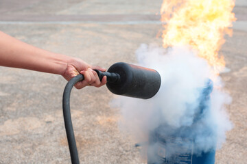 Employees firefighting training, Concept Employees hand using fire extinguisher fighting fire closeup	
