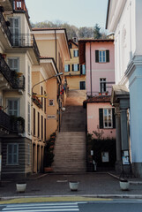 Steep stone stairway linking pastel colored houses nestled on Lake Maggiore's hillside in Belgirate, Piedmont, revealing traditional Italian architectural charm