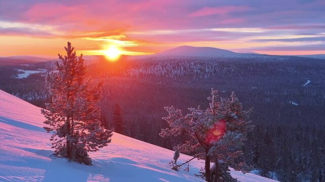 Aerial view of sunset over snow-covered forest and mountains, Finland.