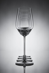 Row of empty wine glasses on a gray reflective background. Set of wine glasses. Shallow depth of  field.