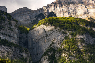 Mountain peak with trees, Switzerland, Canton St. Gallen, Swiss Alps, Frümsel mountains. Sunny day, clouds, mountain range. Hiking, tourism, travel destination, recreation.