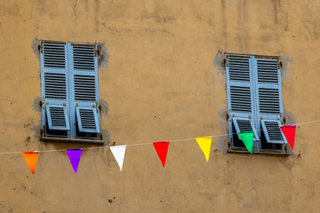 Colorful bunting and blue shutters on old wall, France, Corsica, Ajaccio, 13 June 2025