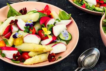 A bowl of mixed greens salad with edible flowers.