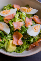 delicious and healthy salad with smoked salmon, boiled egg, greens, and fresh vegetables