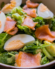 delicious and healthy salad with smoked salmon, boiled egg, greens, and fresh vegetables
