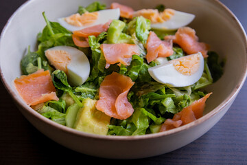 delicious and healthy salad with smoked salmon, boiled egg, greens, and fresh vegetables
