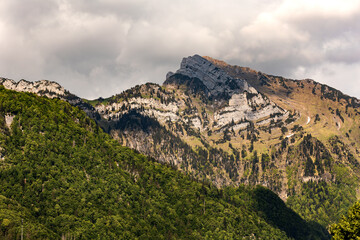Hinterrugg mountains with trees, Switzerland, Canton St. Gallen, Swiss Alps. Sunny day, clouds,...
