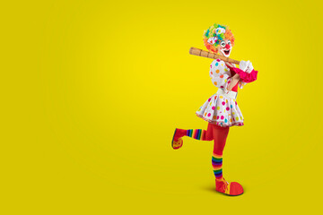Funny female clown club-swinging. Entertainer woman Joker in colorful suit and wig. Buffoon with clown whiteface makeup. Trickster, jester, pantomime, mime. Professional actor.