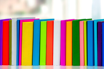 Books in multi-colored covers on an bookshelves. Literature for children. Collection in the...