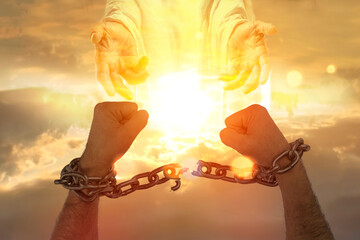 Men's hands breaking chains against the sky with a symbolic hands of Christ the Savior. Concept of...